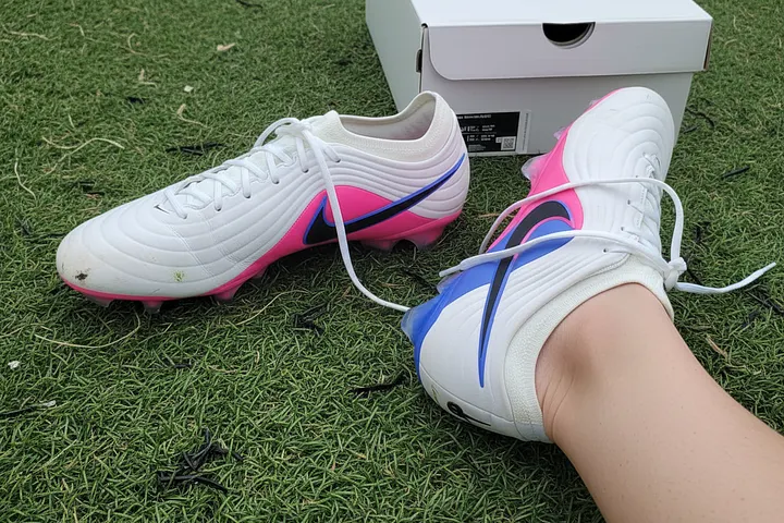 AI-generated UGC-style photo of Nike Tiempo Maestro Elite football boots on grass, next to their shoe box